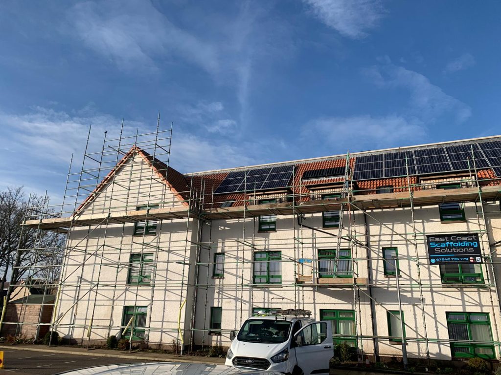An image of a cream house with scaffolding in front and up along it. Ready for Edinburgh EES pest control to install pigeon proofing solar panels